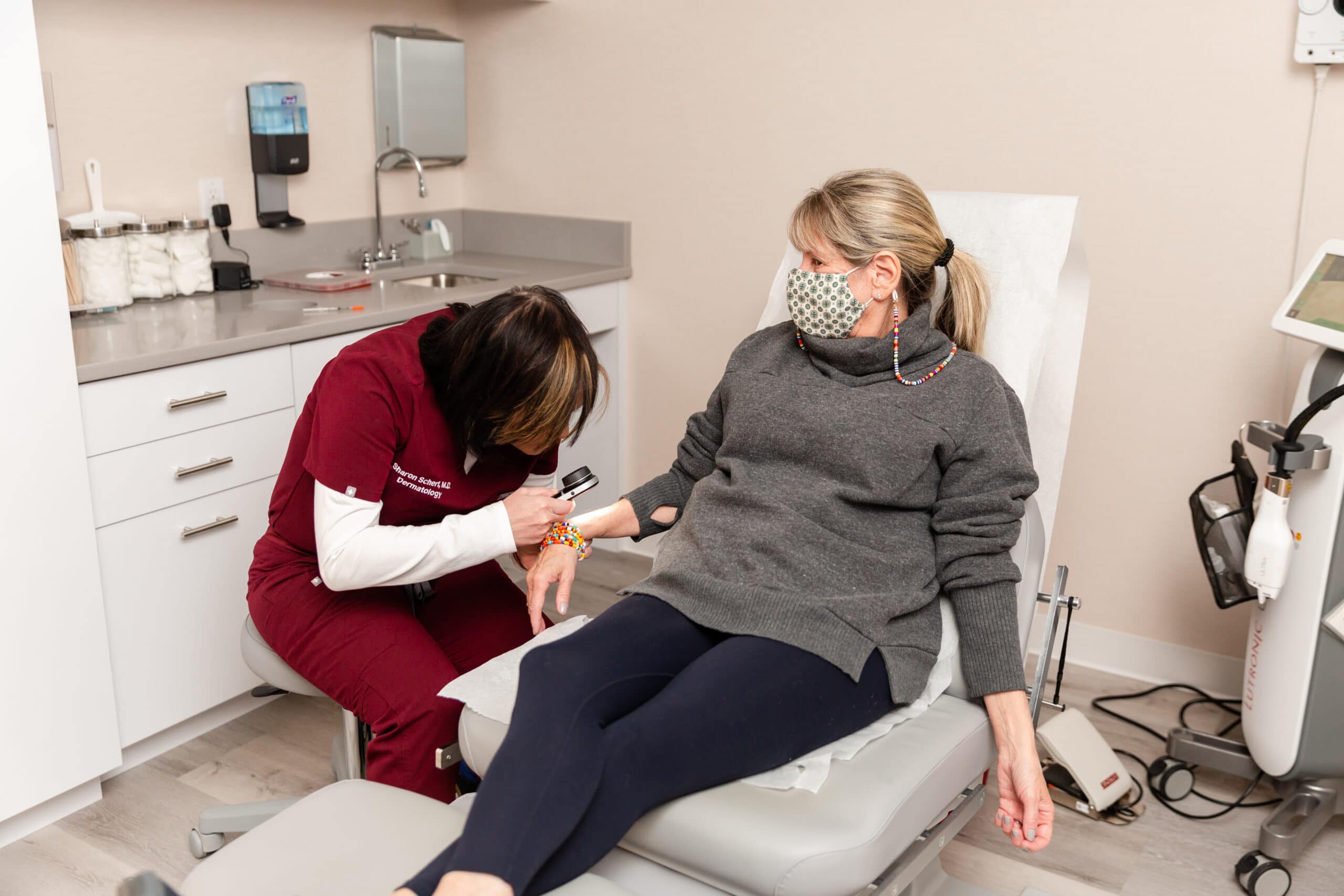 dermatologist examining patient's skin