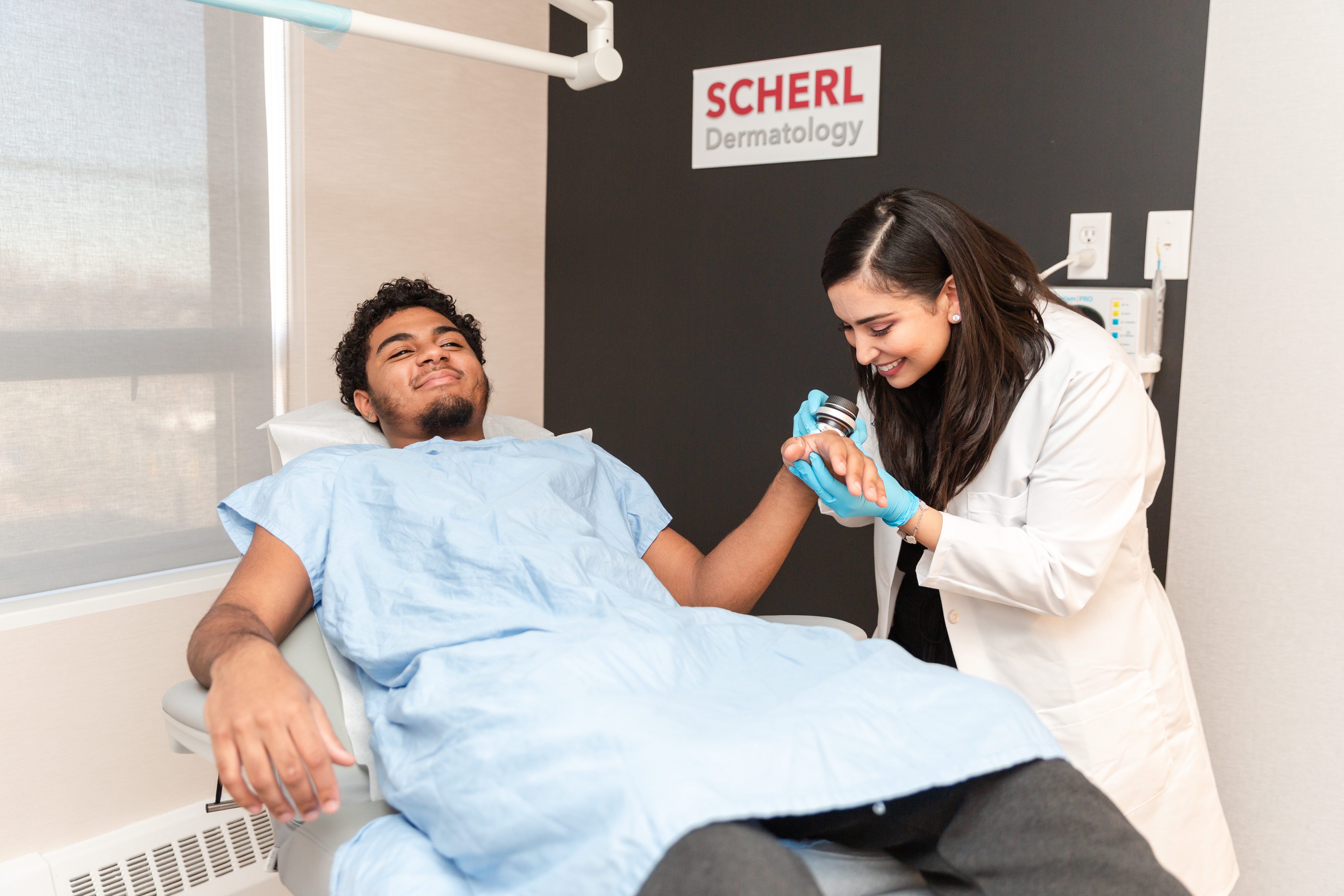 dermatologist examining patient's skin 