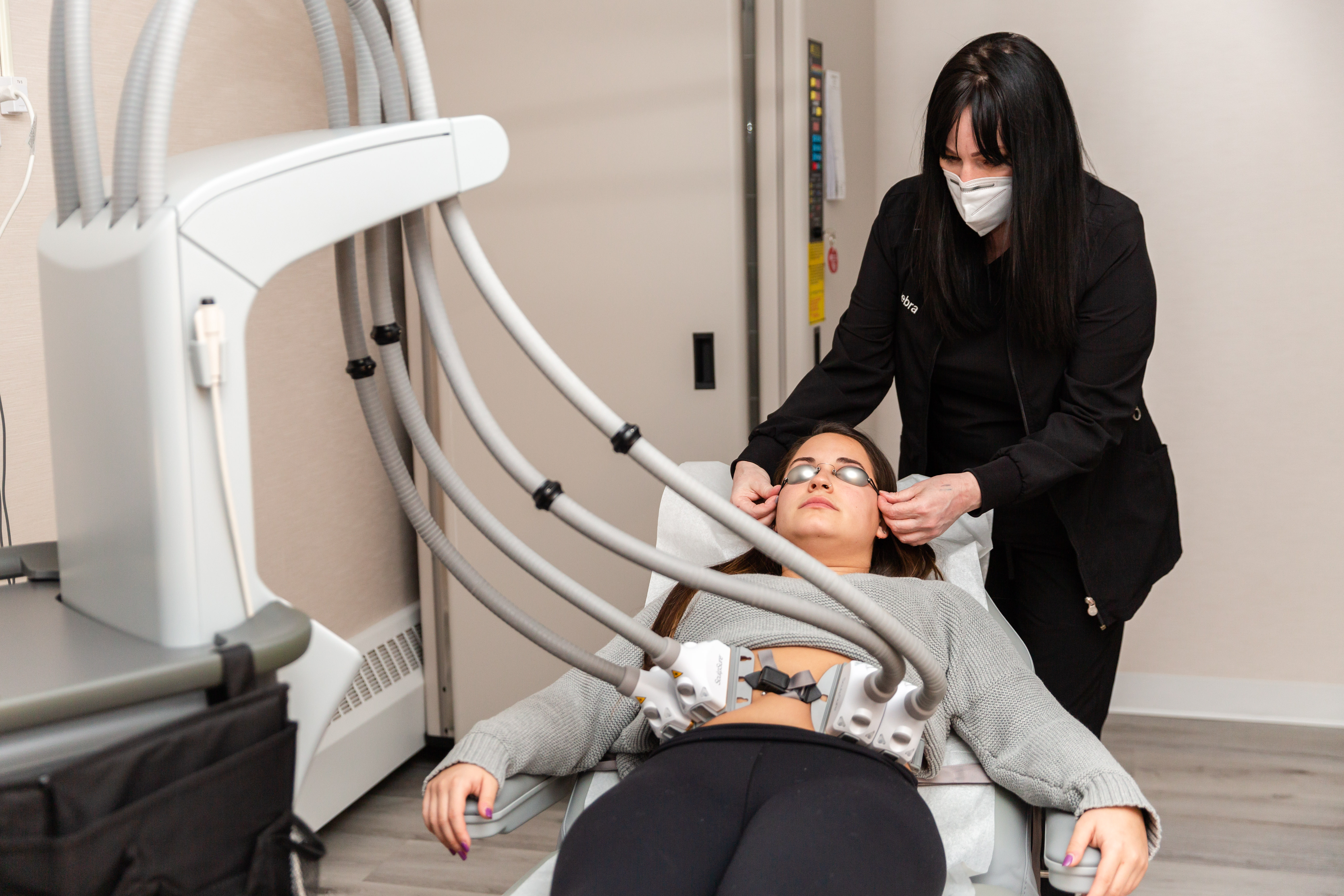 doctor performing a sculpsure treatment on a female patient from Englewood Cliffs